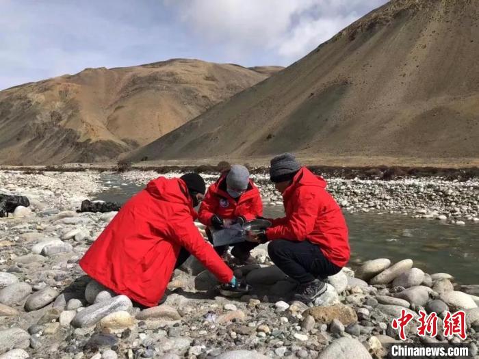 图为冰川微生物科考分队队员，在4500米的海拔下，使用土壤筛、自封袋、铲子采集土壤样品。　兰州大学供图